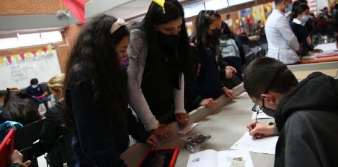 Estudiante y su madre recibiendo una tablet entregada por la Alcaldía Local de Suba