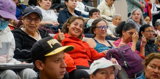 Personas en un auditorio sonriendo