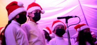 Niños del coro de Batuta de Suba, cantando villancicos, con gorros de navidad