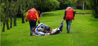 Dos personas cargando un basura en operativo de limpieza